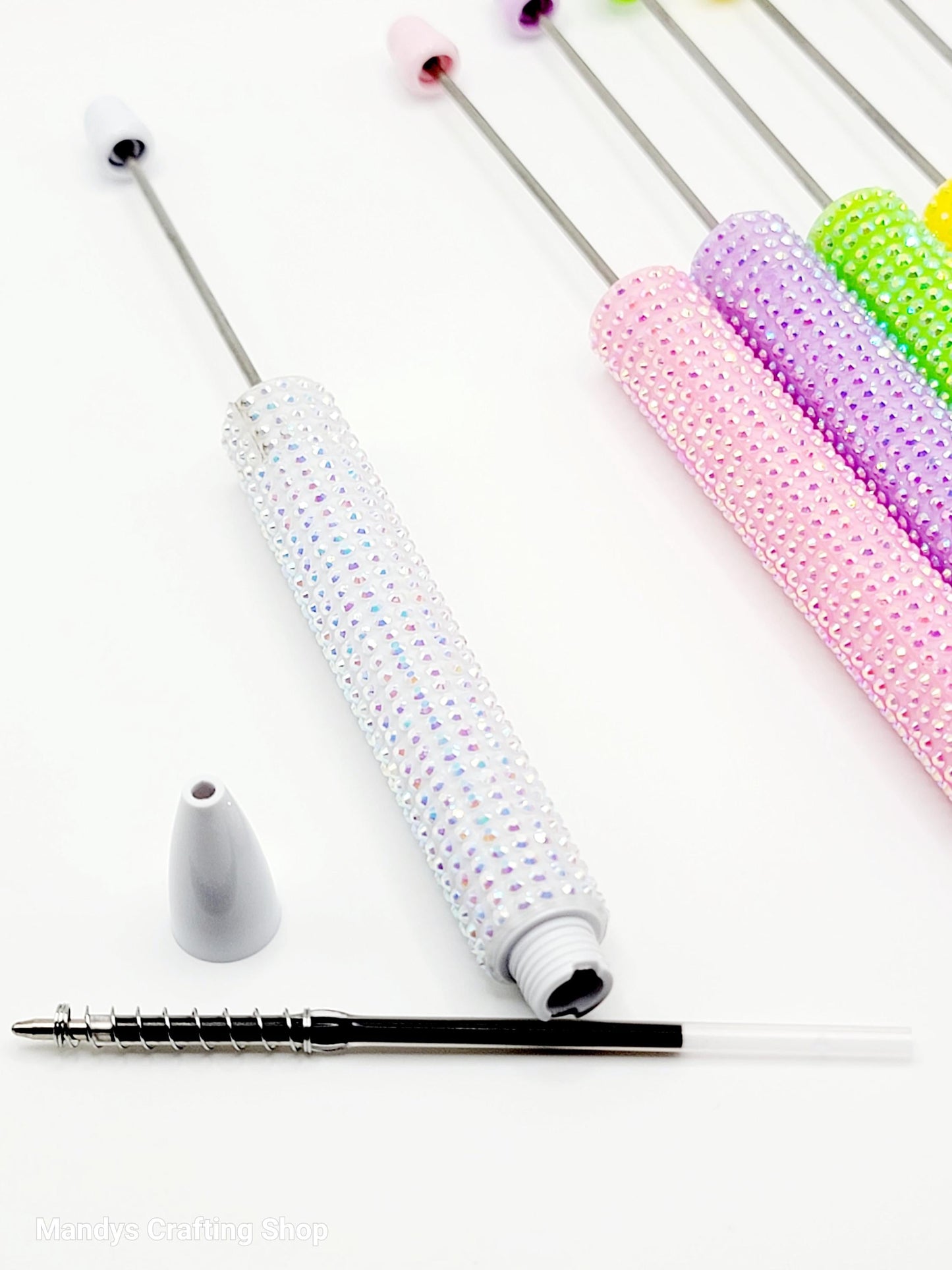 Set of colorful beaded pens on a white background