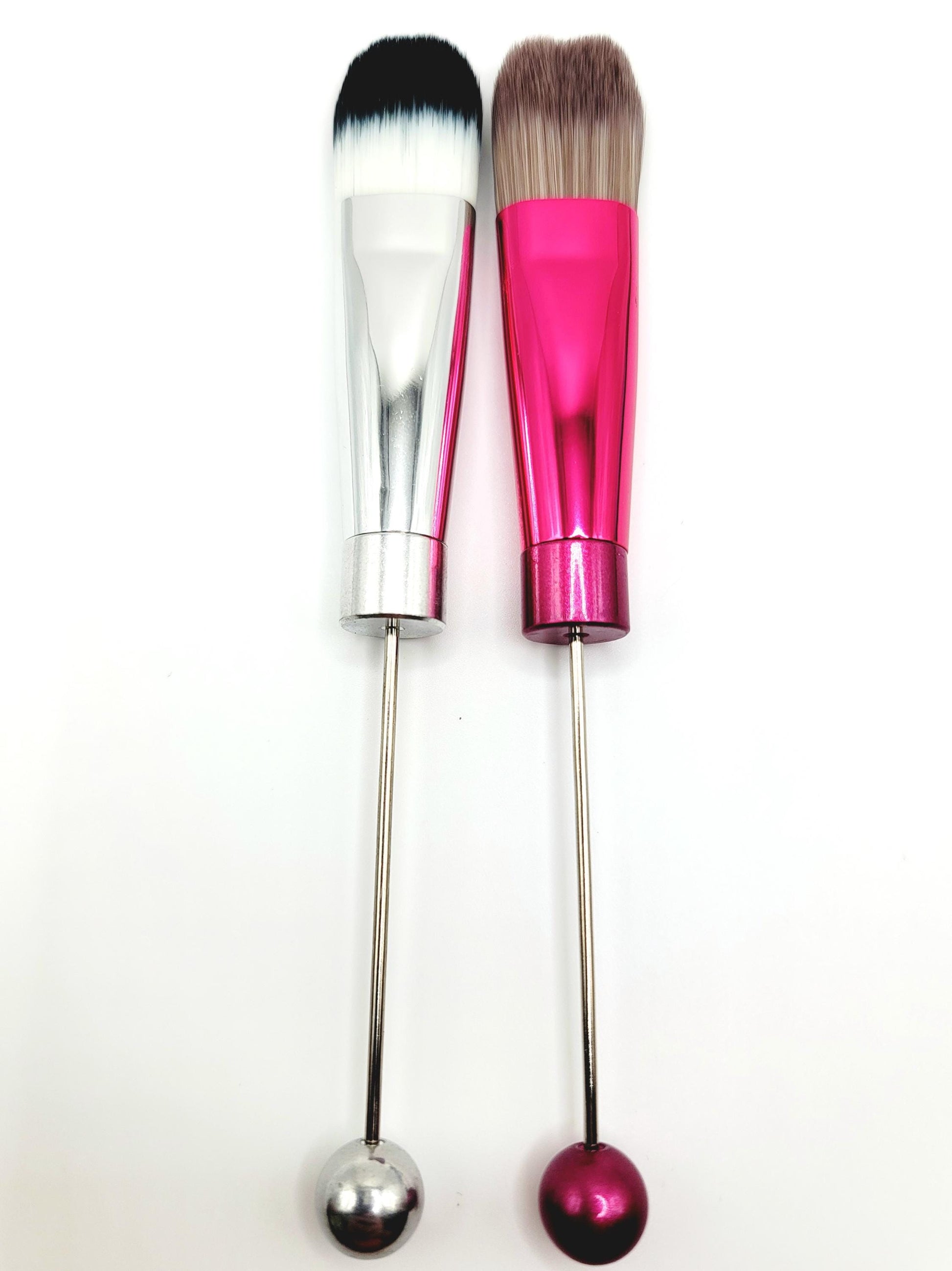 Two makeup brushes with pink and silver handles on a white background