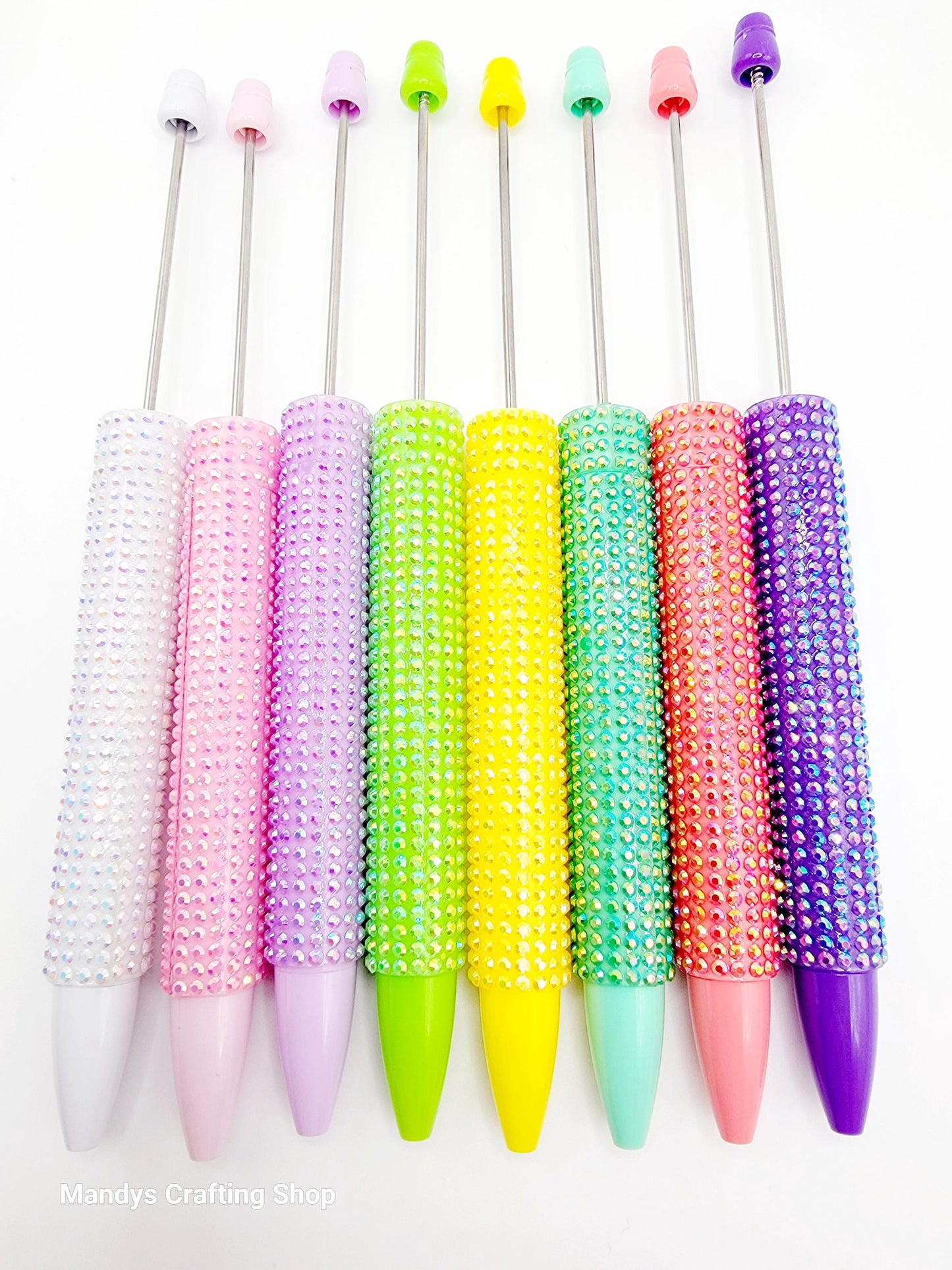 Colorful beaded pen caps on a white background
