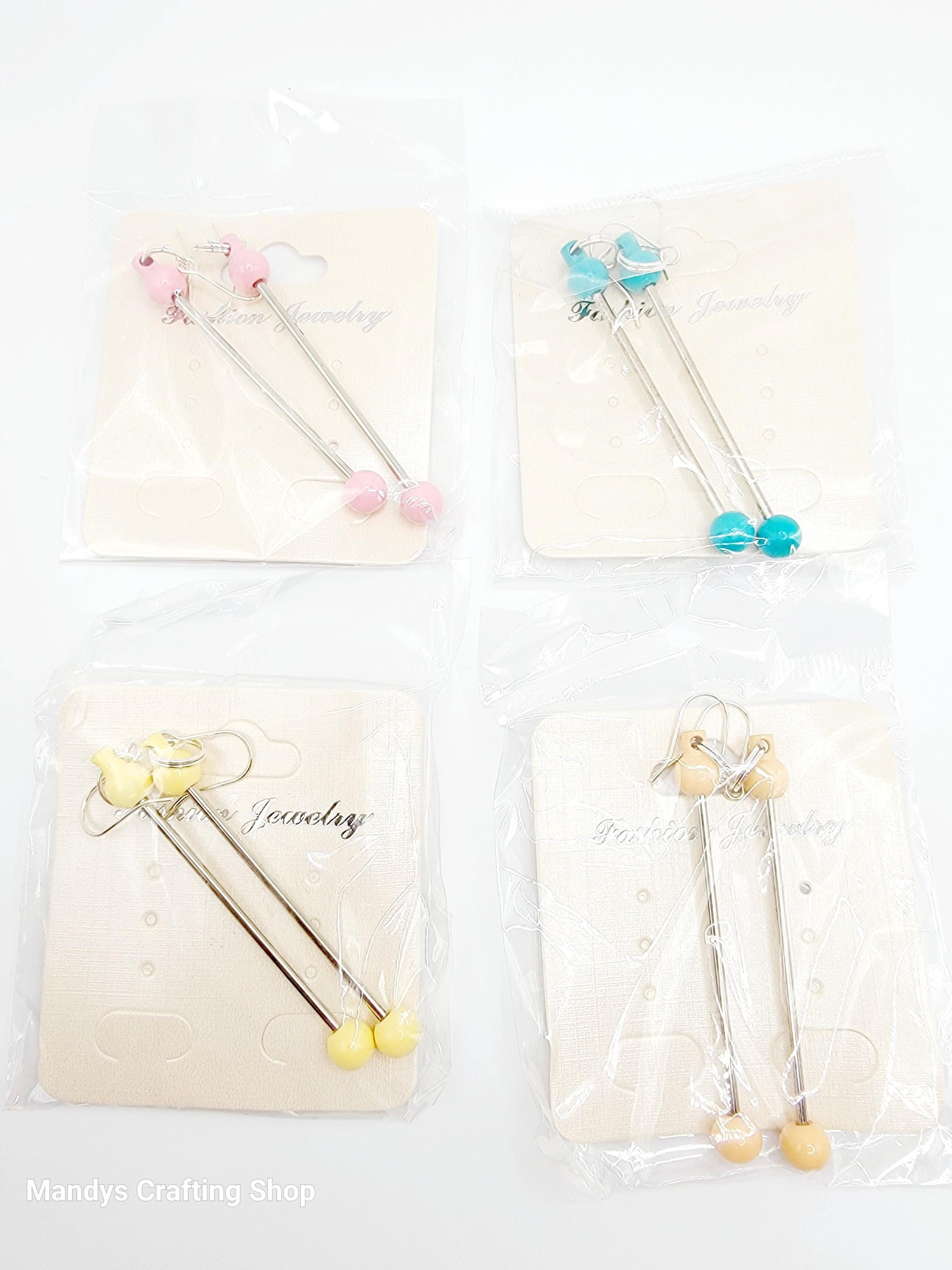 Set of four decorative sticks with colorful beads and butterfly designs on a white background.