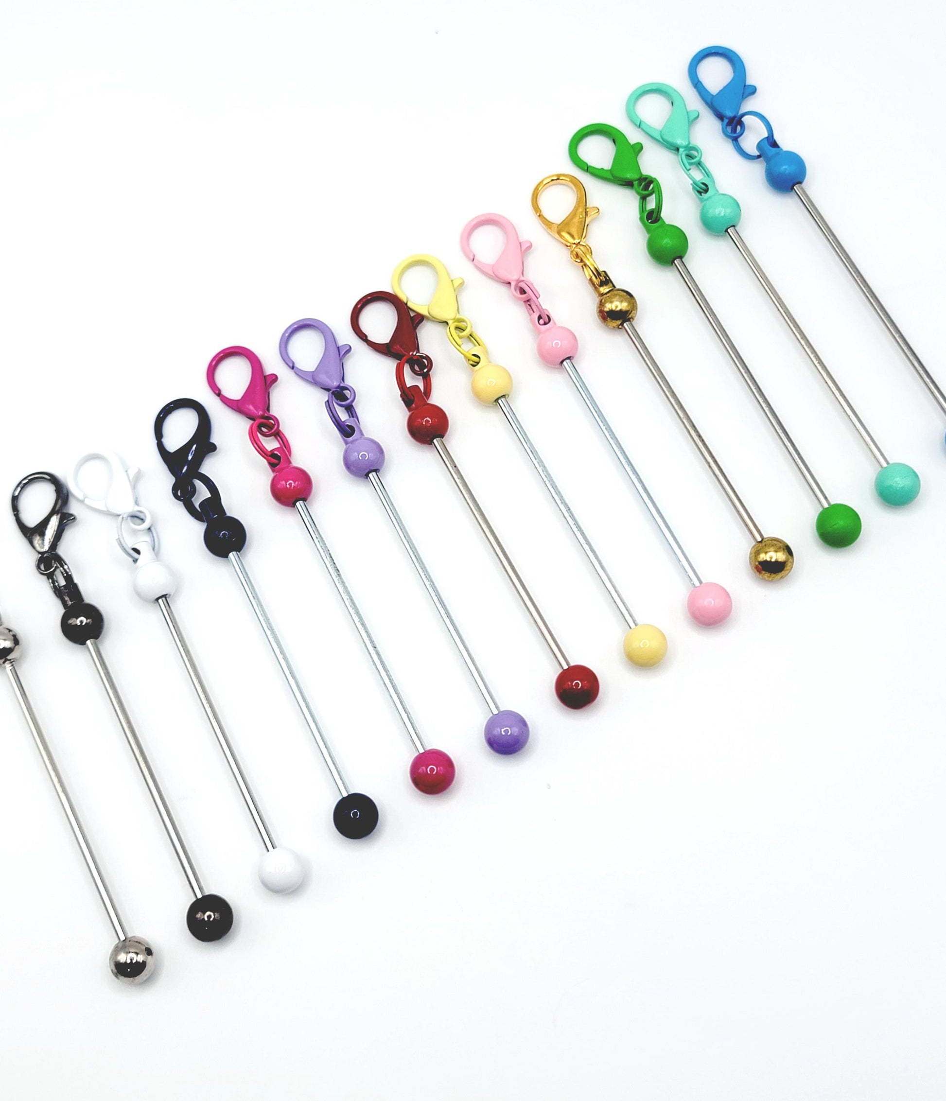Set of colorful keychain sticks with various attachments on a white background