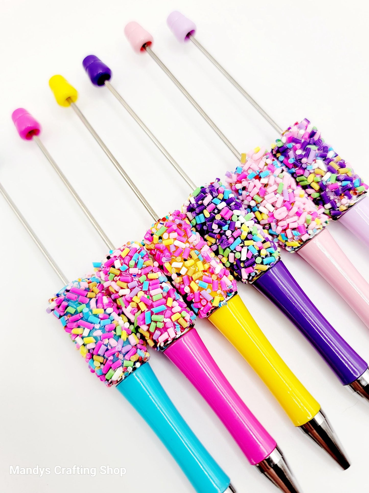 Colorful swizzle sticks with sprinkles on a white background