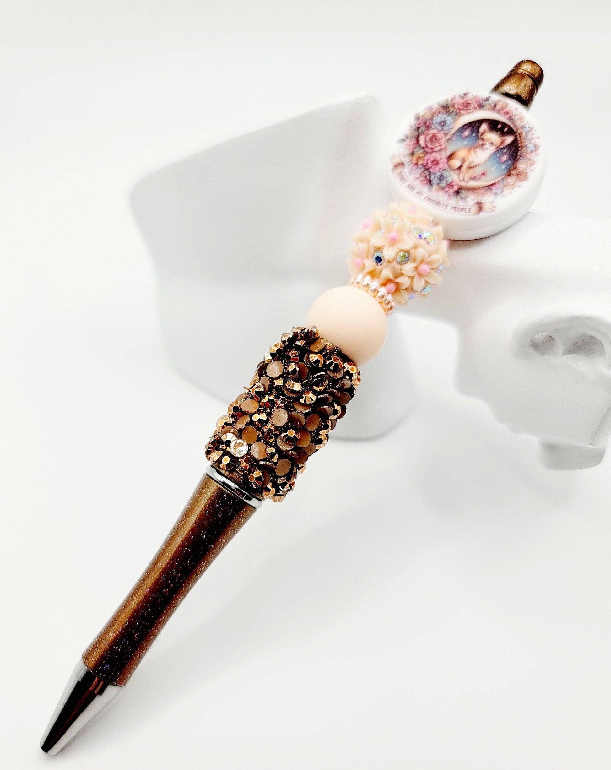 Decorative pen with gemstone accents and a photo charm on a white background