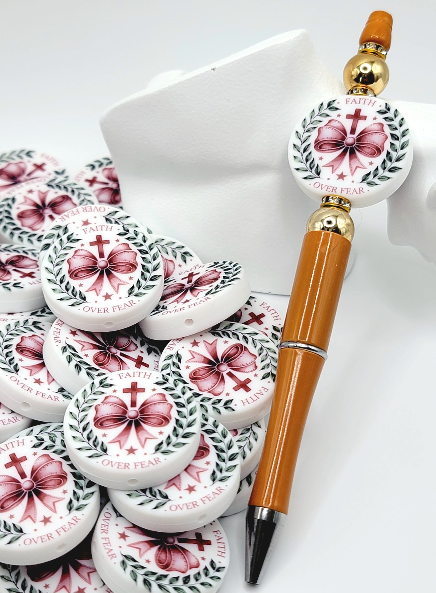 Decorative pen with floral design and small containers on a white surface