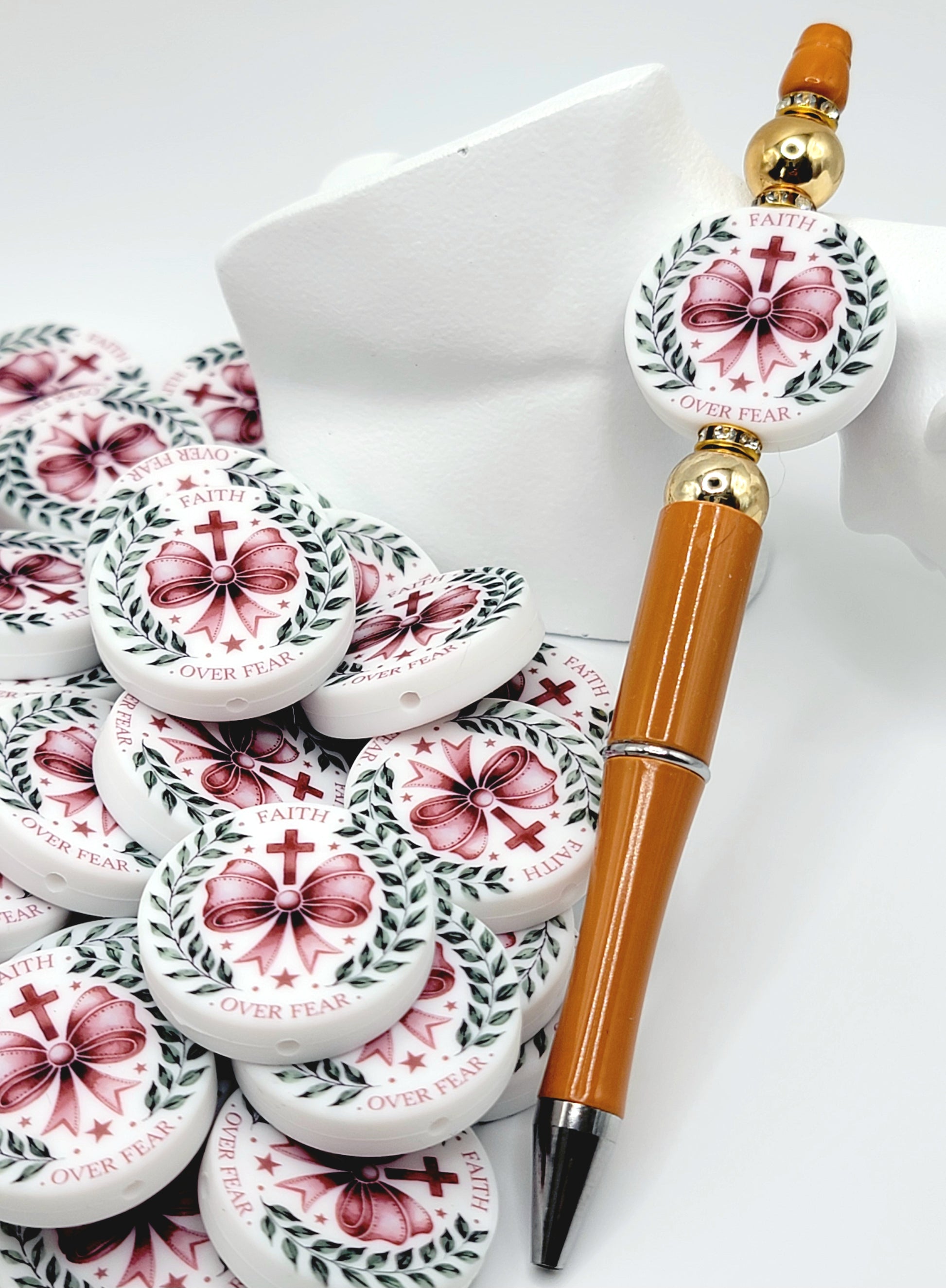 Decorative pen with floral design and small containers on a white surface