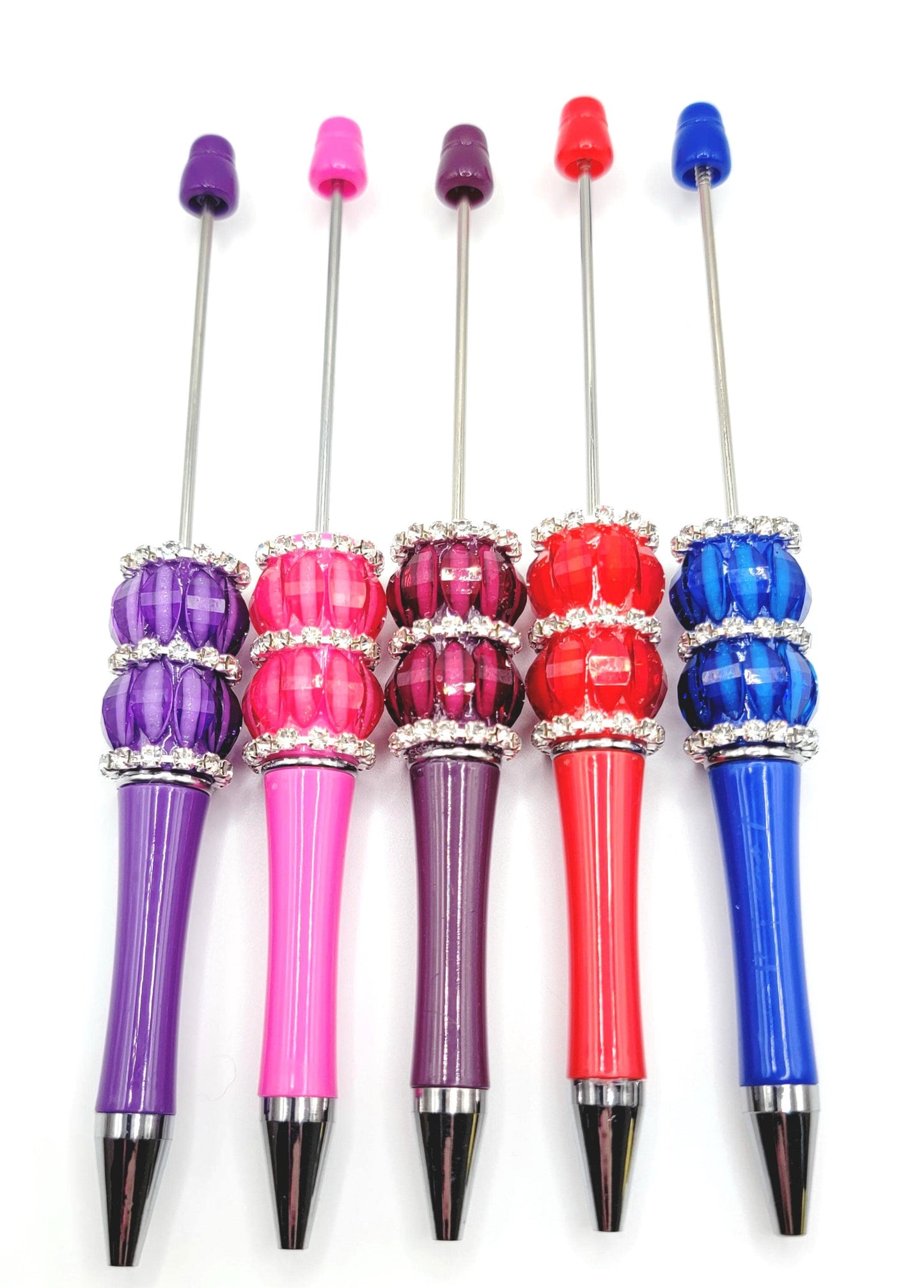 Set of colorful pens with decorative caps on a white background