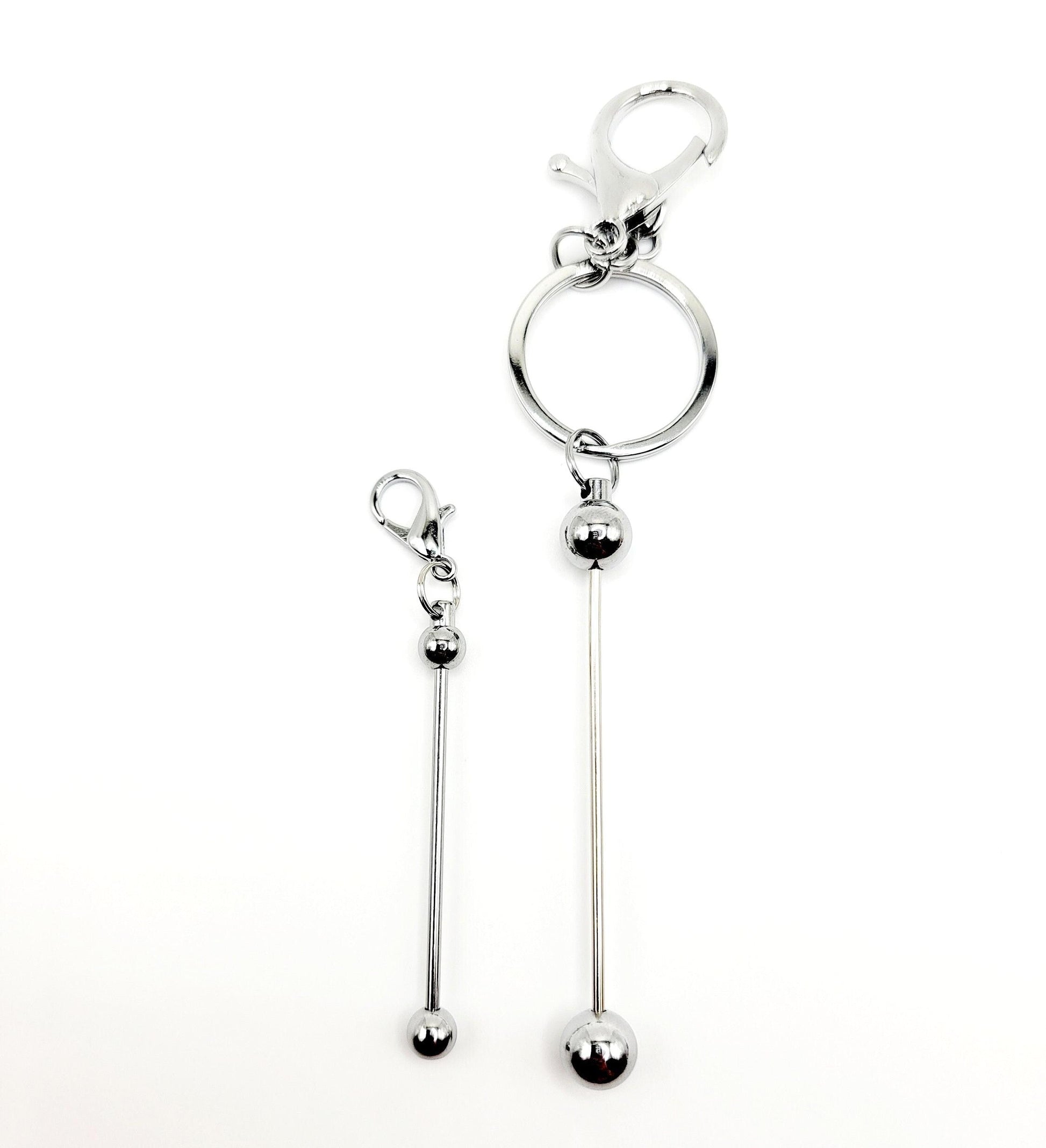 Silver keychain with a long hanging ball on a white background