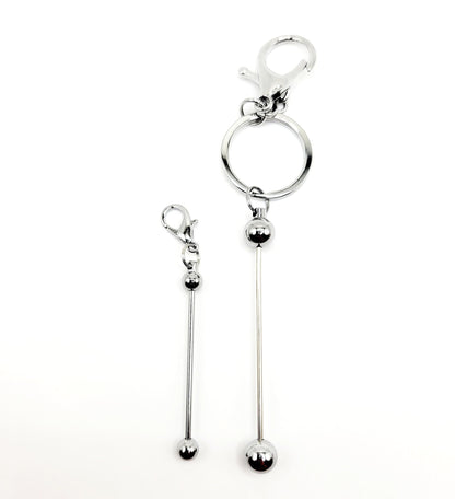 Silver keychain with a long hanging ball on a white background