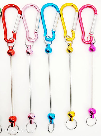 Set of colorful keychain carabiners with metal loops and bell charms.