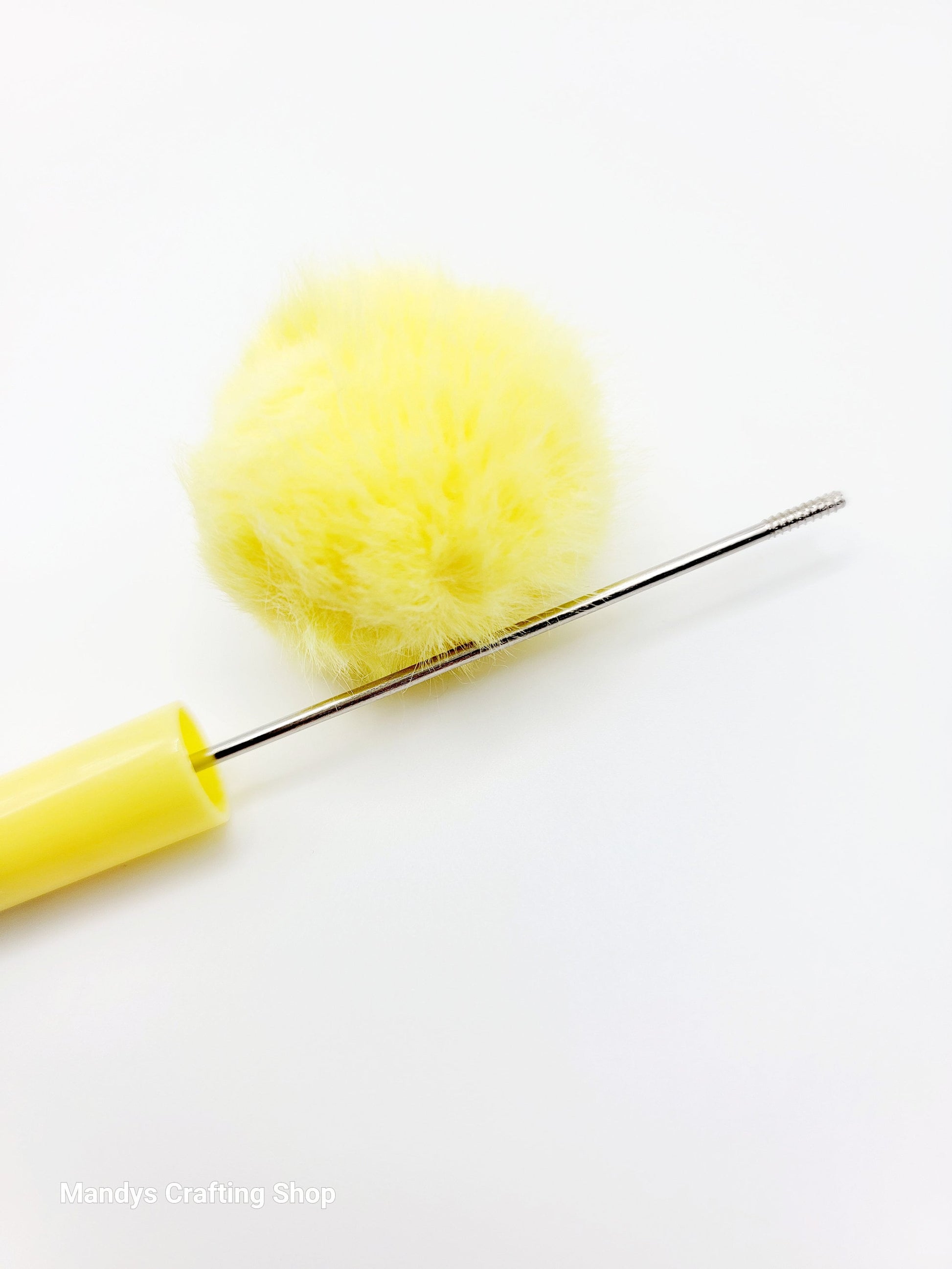 Yellow pom-pom maker with a yellow pom-pom on a white background