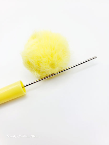 Yellow pom-pom maker with a yellow pom-pom on a white background