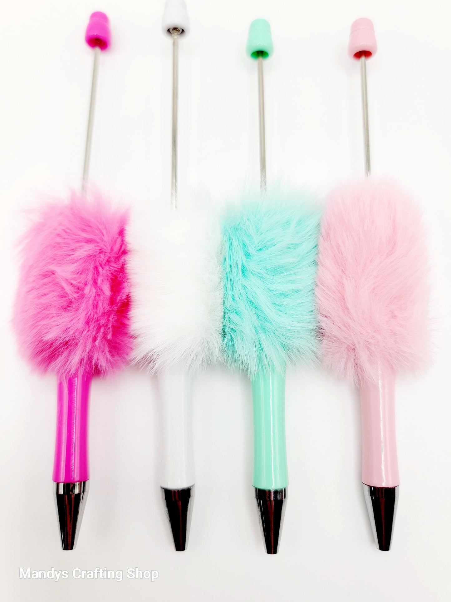Four fluffy pens with colorful tips on a white background