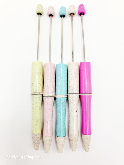 Set of colorful pens with speckled grips on a white background