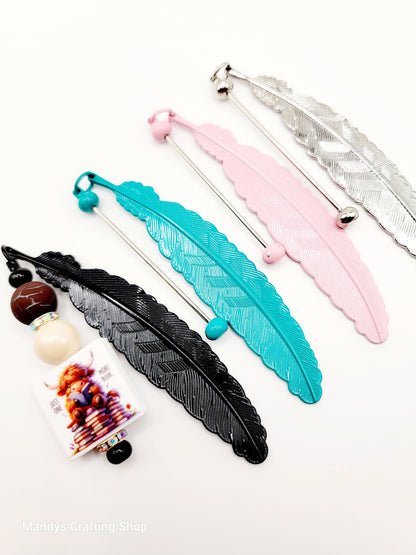 Decorative feather-shaped sticks with beads on a white background