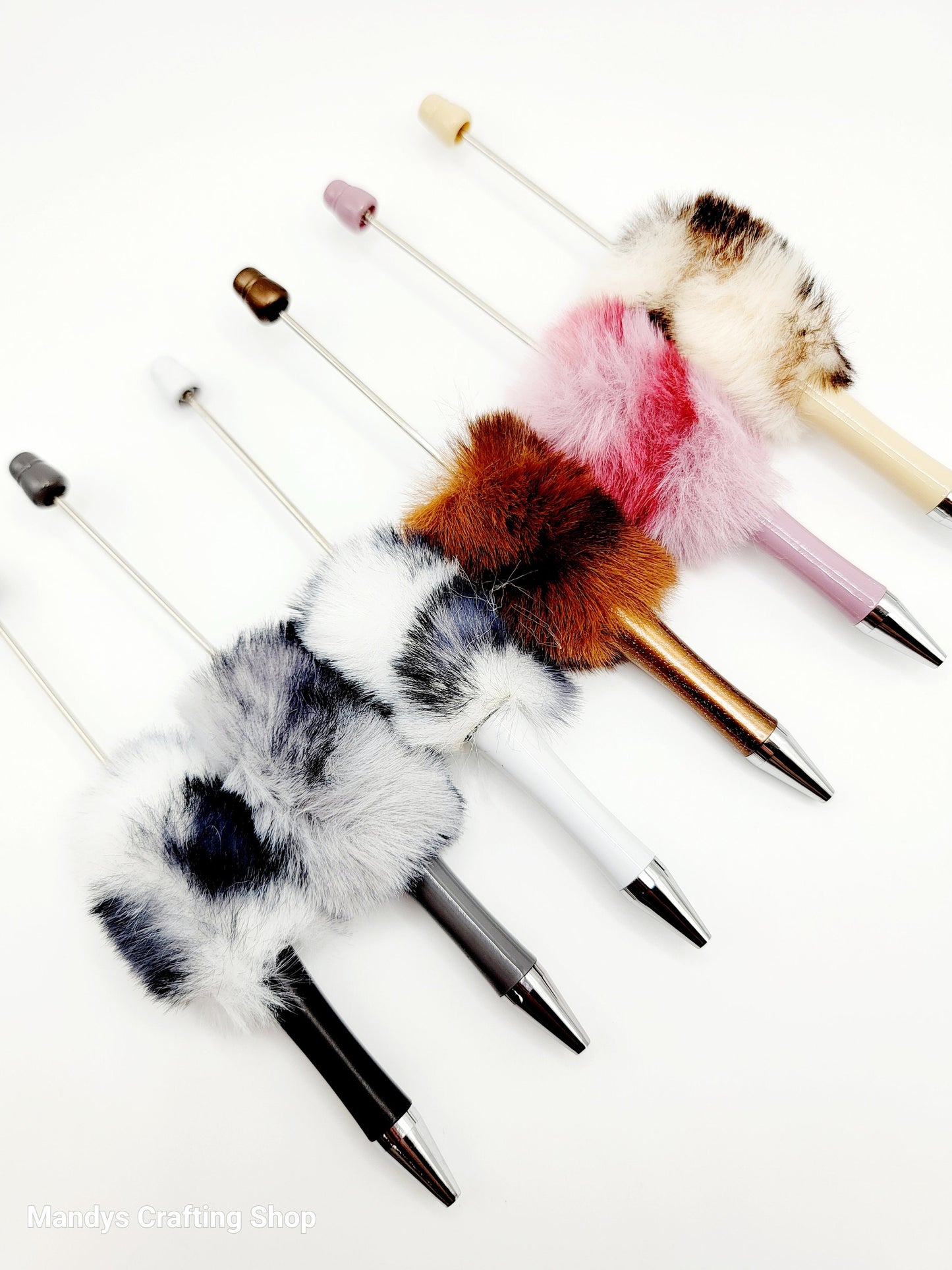 Set of decorative pens with fur accents on a white background