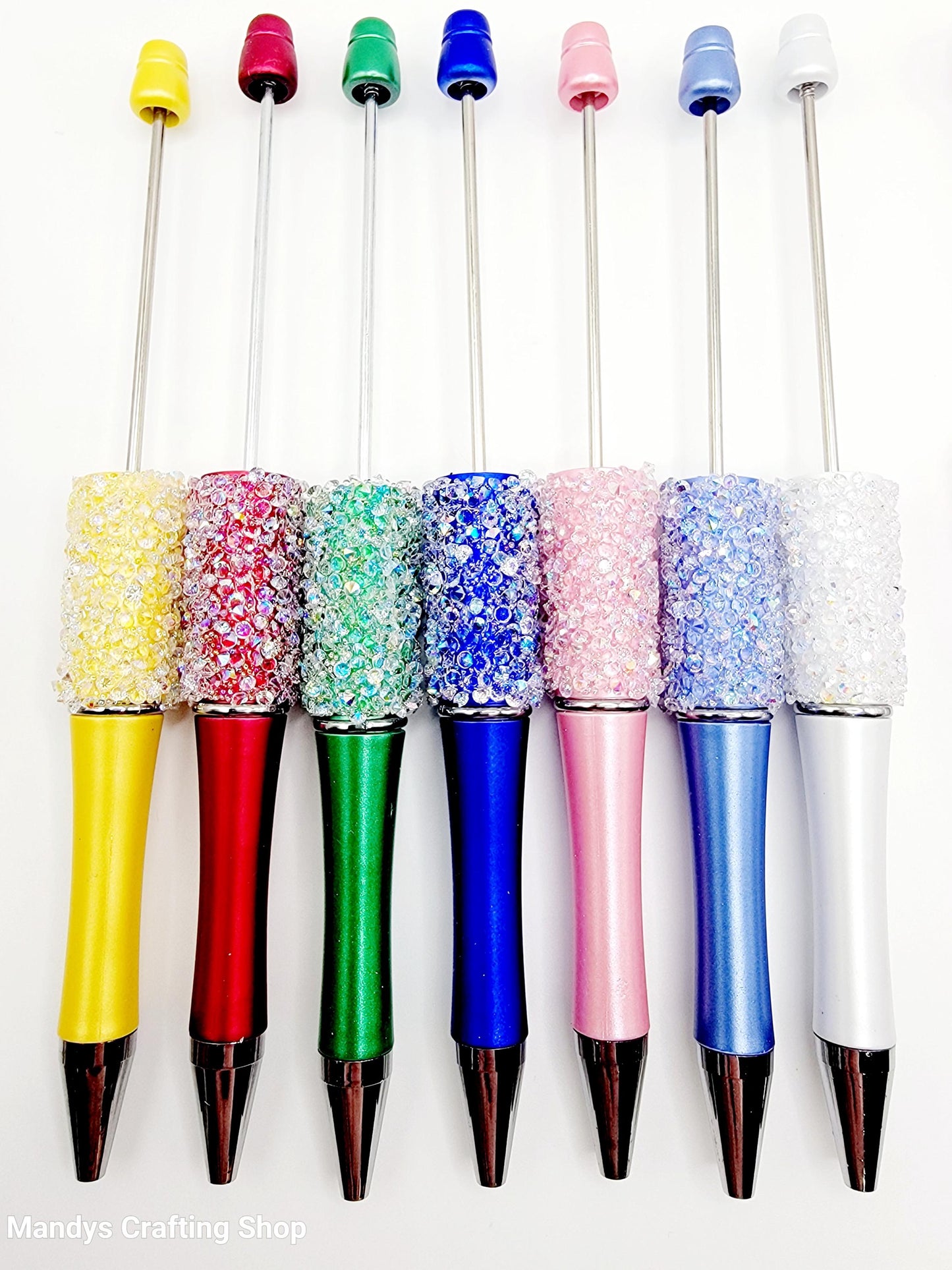Set of colorful pens with decorative caps on a white background