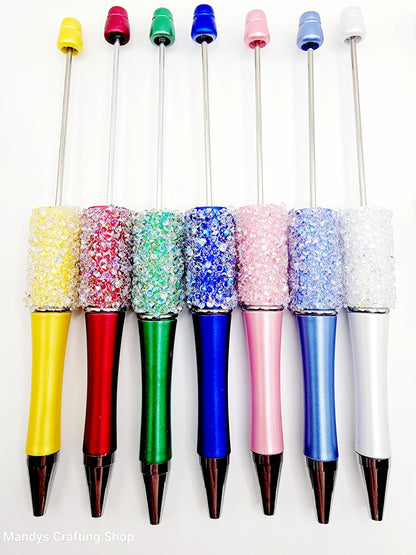 Set of colorful pens with decorative caps on a white background