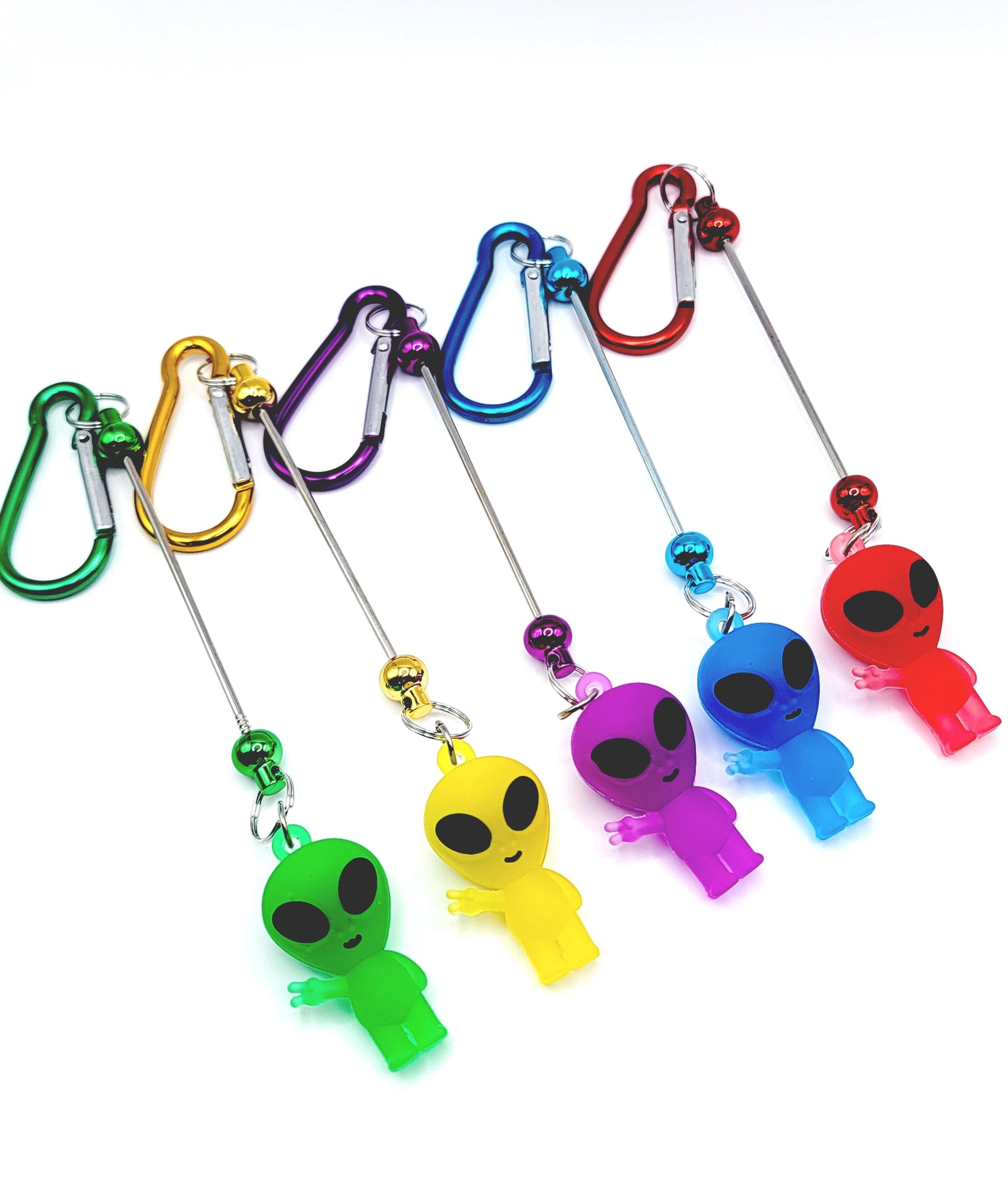 Set of colorful alien-shaped keychains with carabiners on a white background