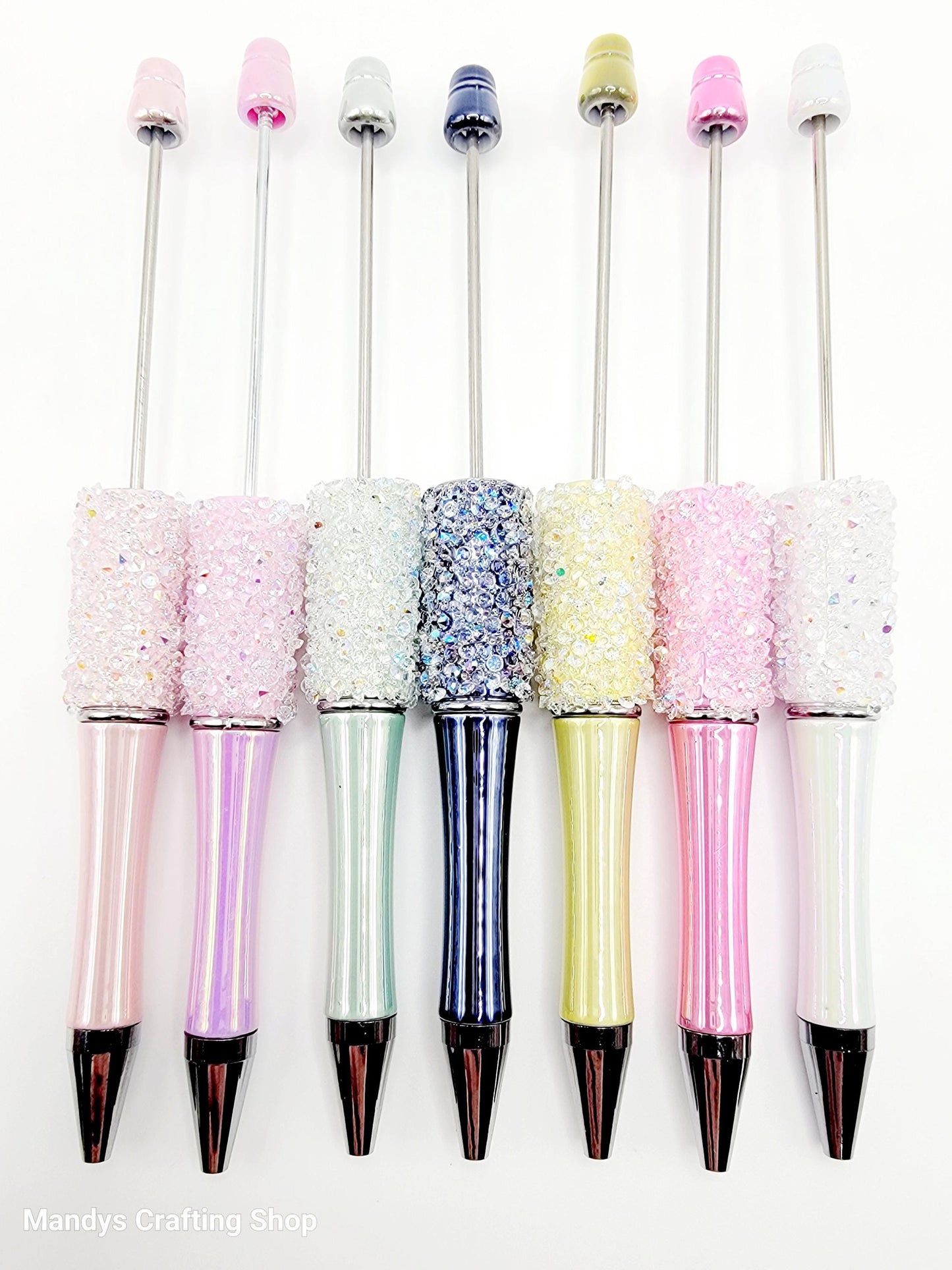 Set of glittery pens with colorful caps on a white background