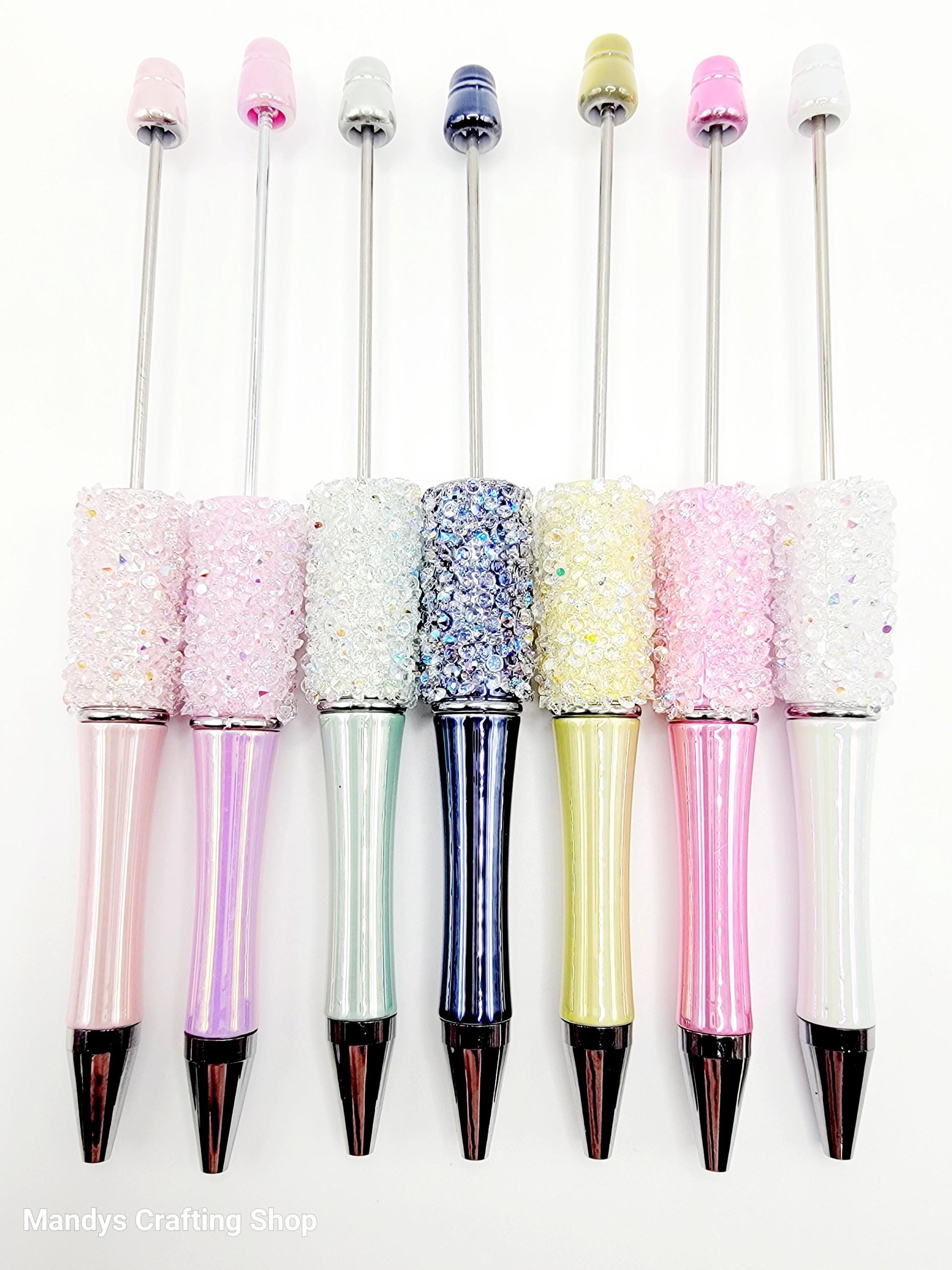 Set of glittery pens with colorful caps on a white background