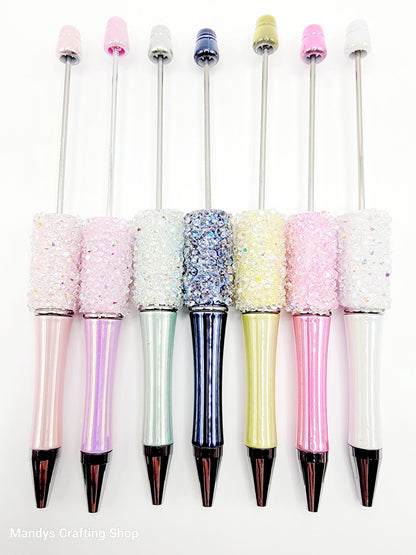 Set of glittery pens with colorful caps on a white background