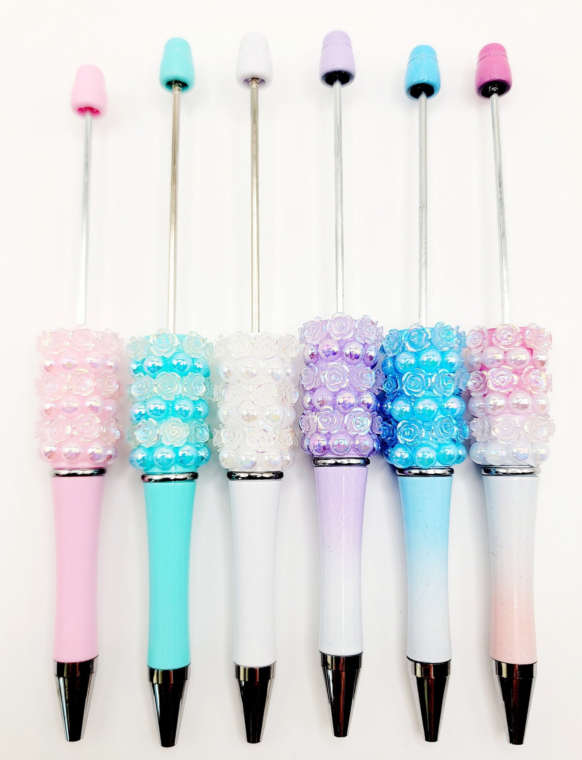 Set of decorative pens with colorful beads on a white background