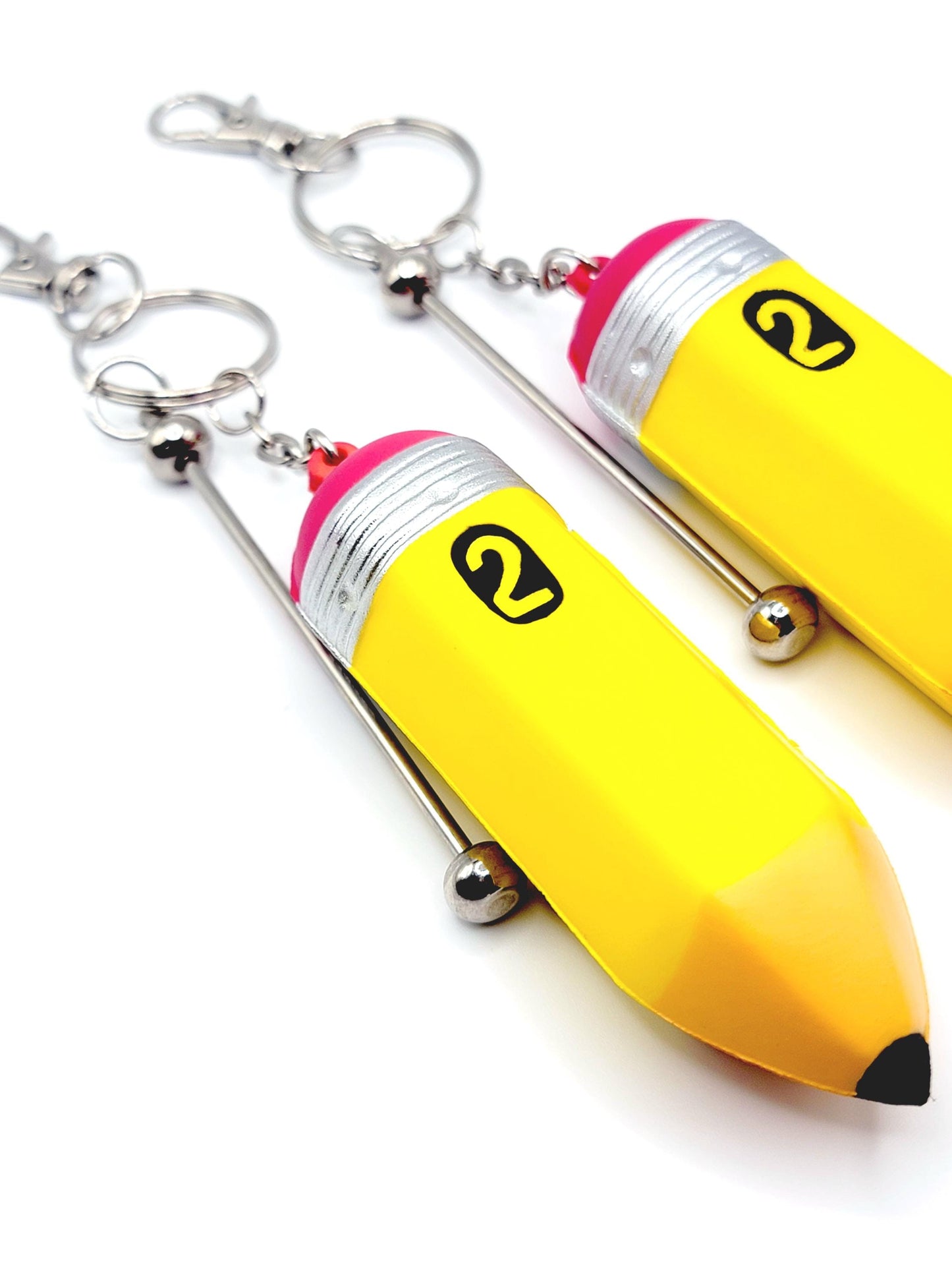 Yellow banana-shaped keychain with a pink top on a white background
