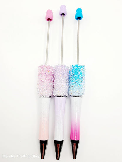 Three decorative pens with pastel-colored tips and glittery bodies on a white background.