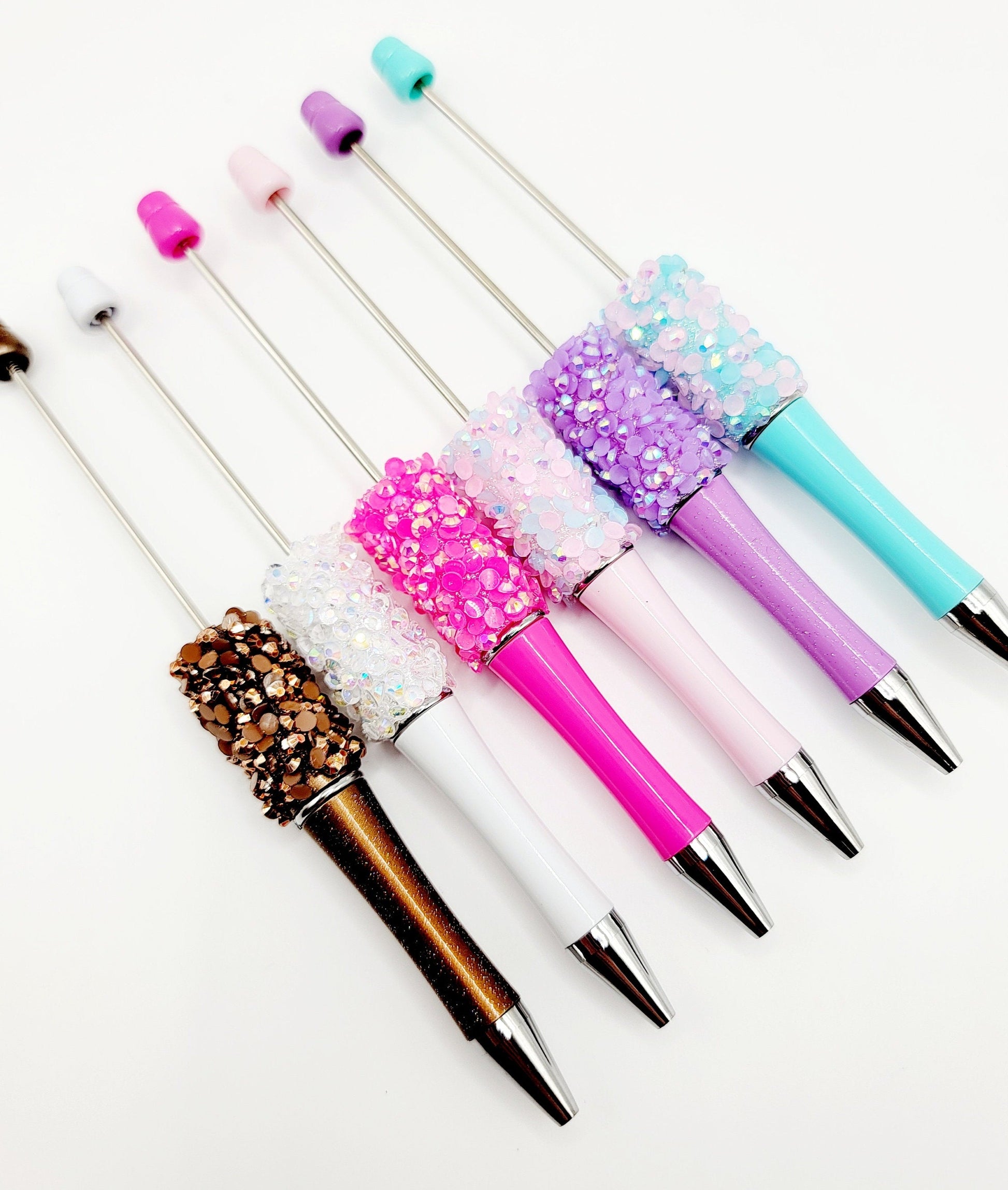 Colorful glittery pens on a white background