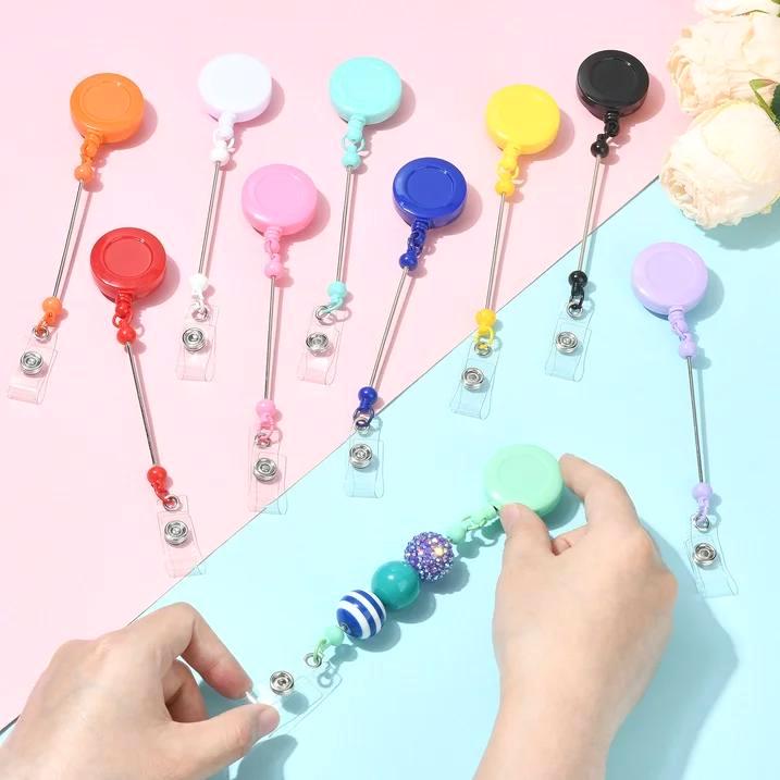 Colorful badge holders with beads on a pink and blue background
