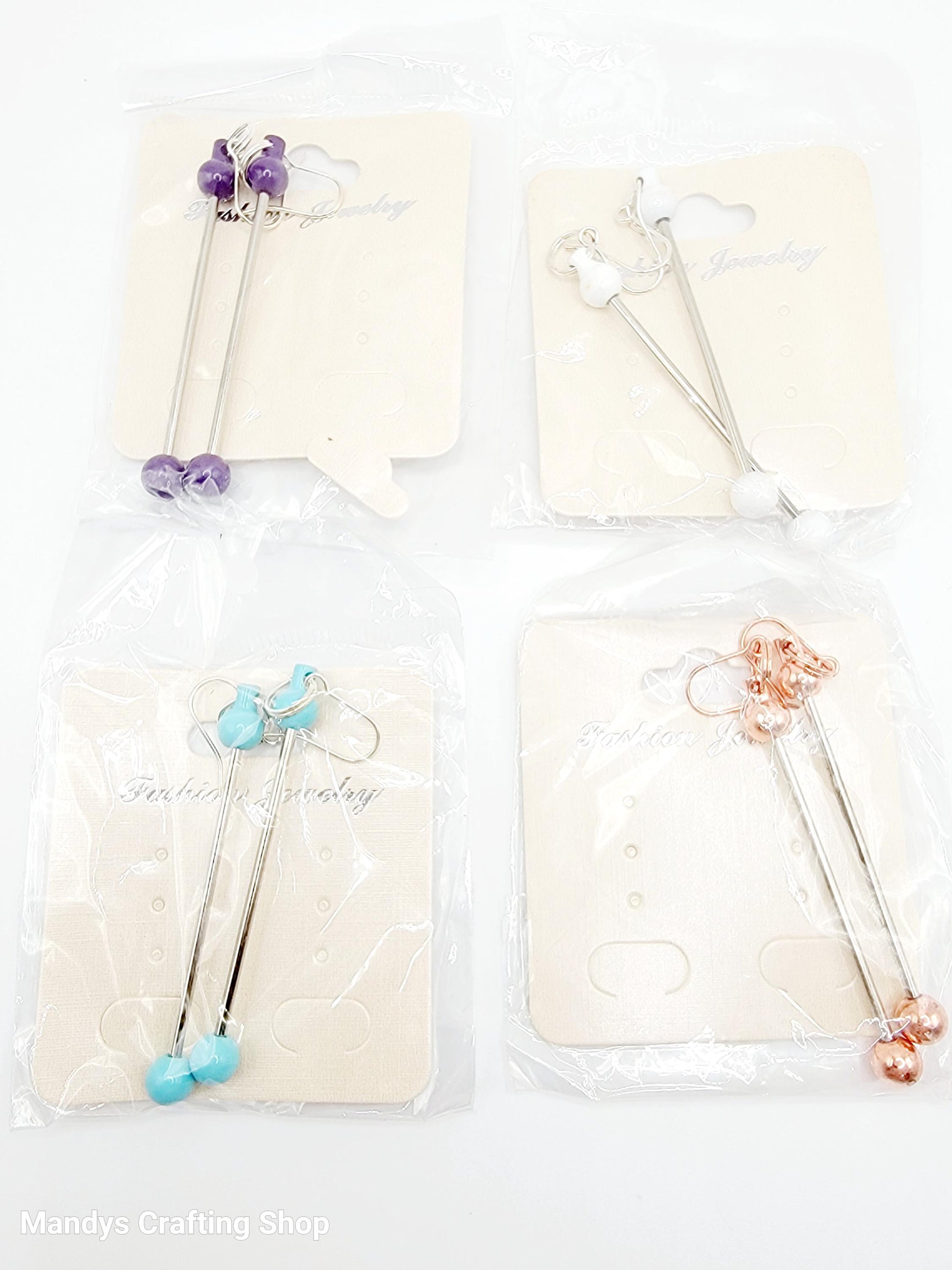 Set of four decorative sticks with colorful beads on a white background, branded 'Mandy's Crafting Shop'.
