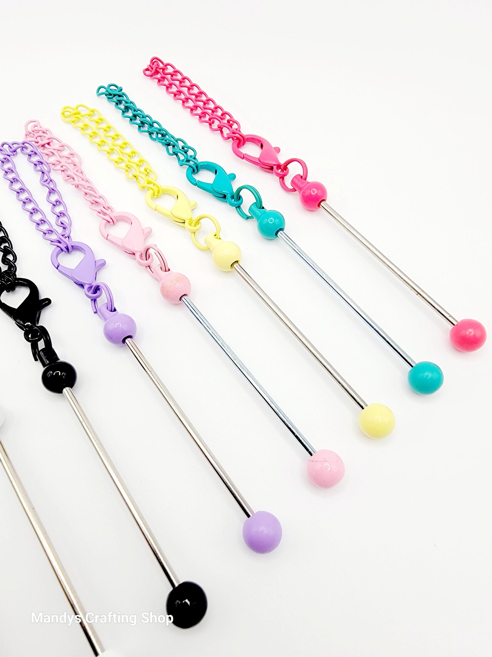 Set of colorful straws with chain and clasp attachments on a white background