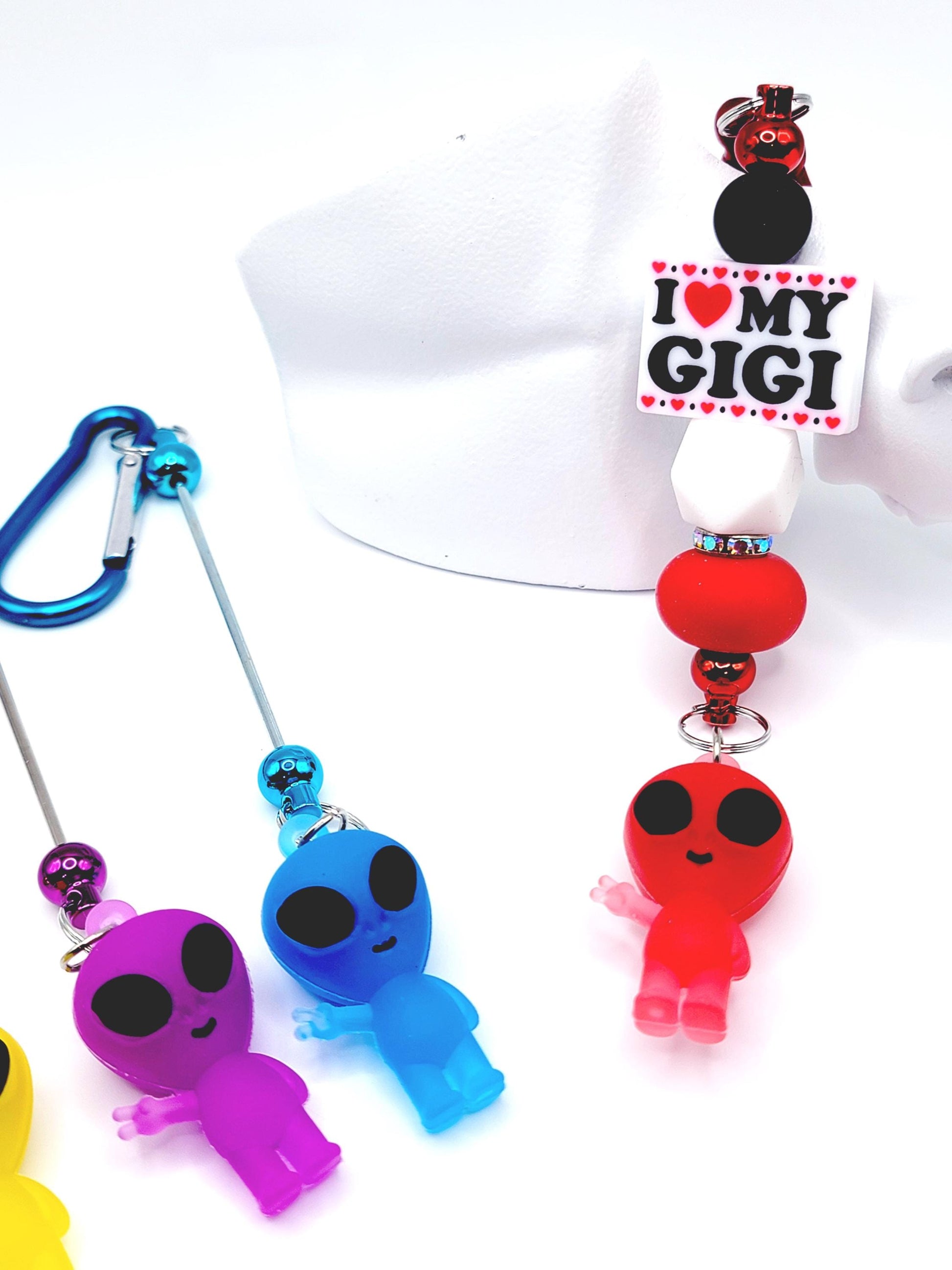 Colorful alien-shaped keychains with a 'I ❤️ MY GIGI' tag on a white background