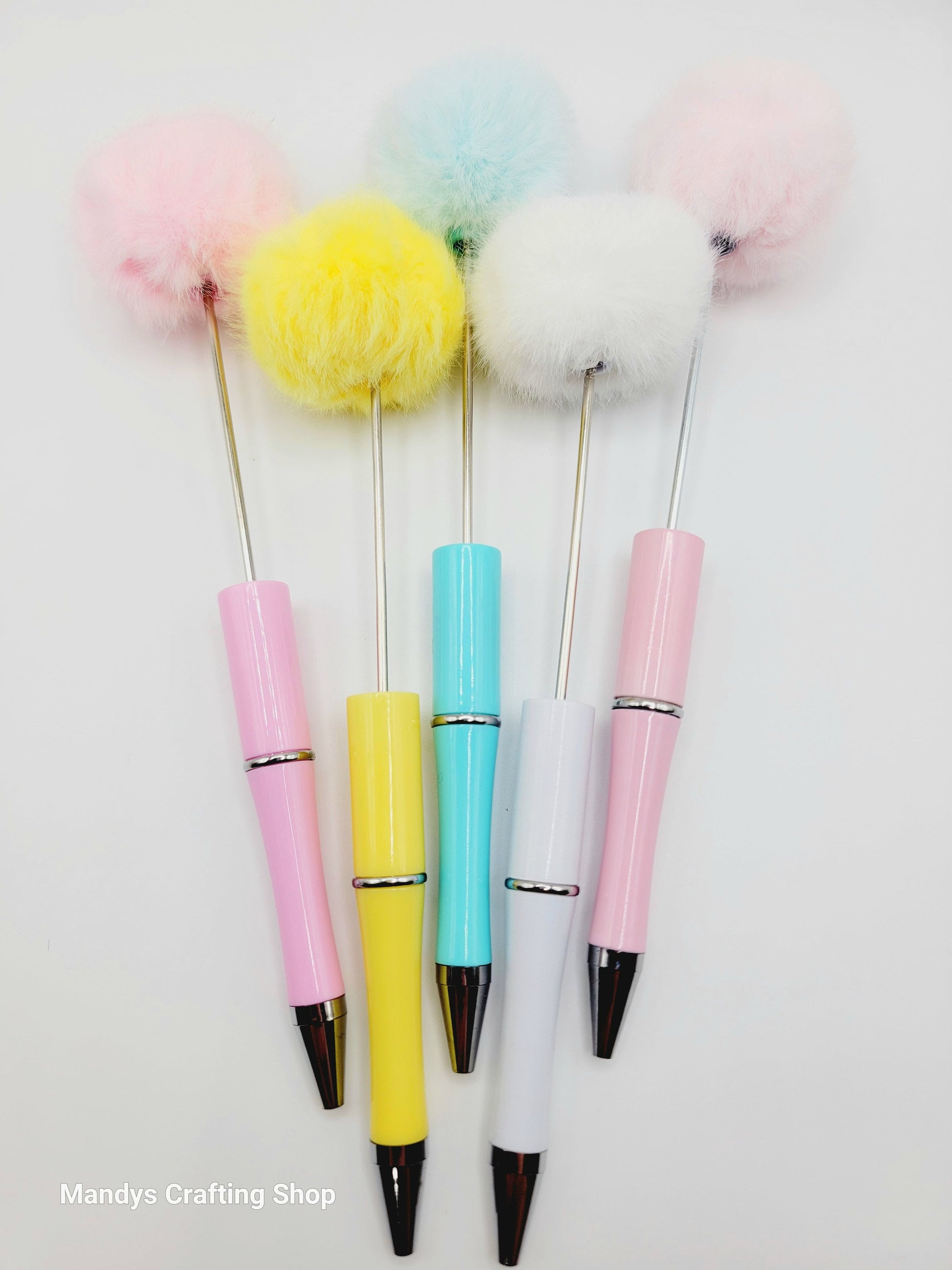 Five colorful pens with fluffy tops on a white background, branded 'Mandys Crafting Shop'.