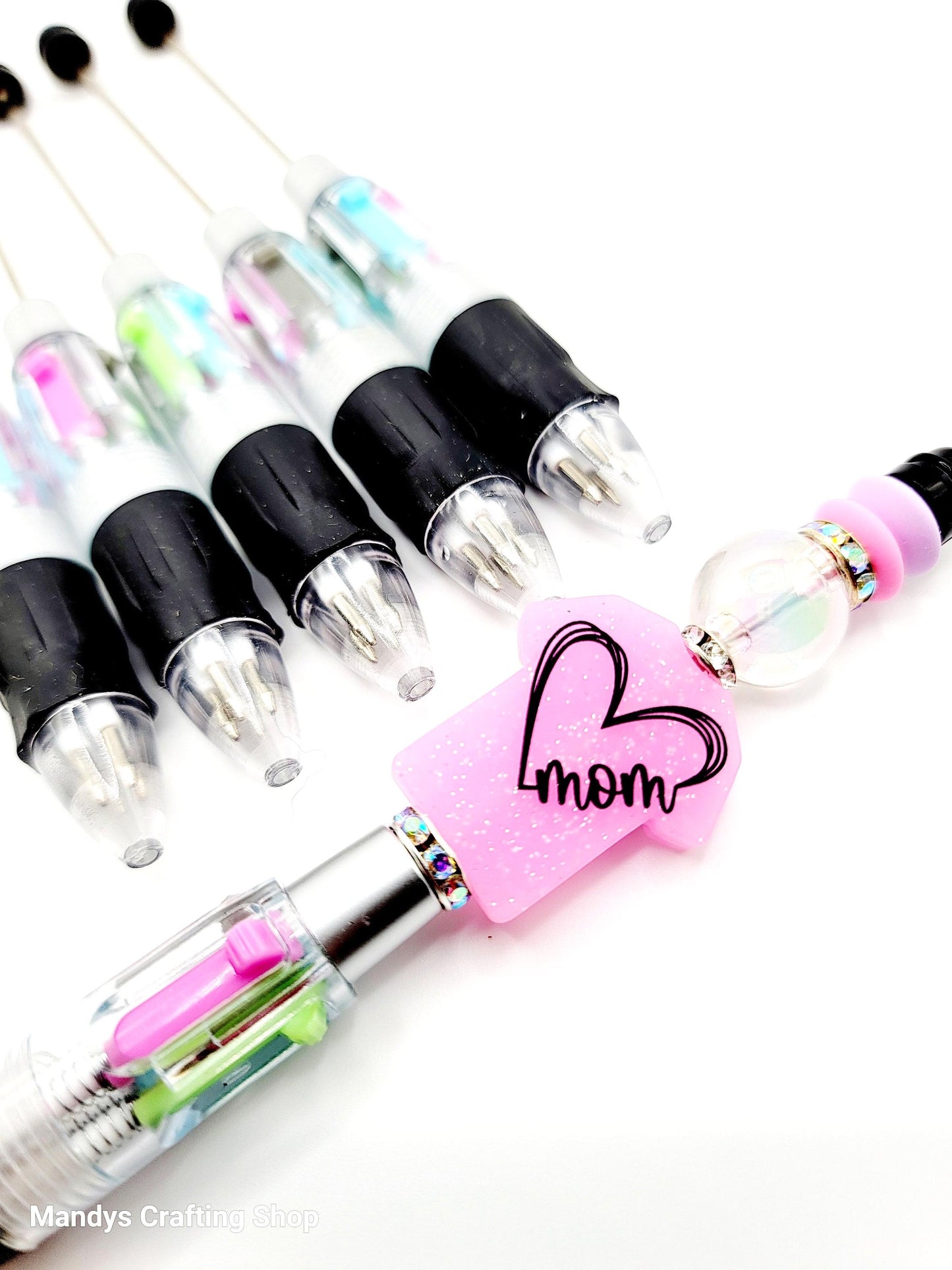 Set of tattoo pens with a pink grip and 'mom' design on a white background