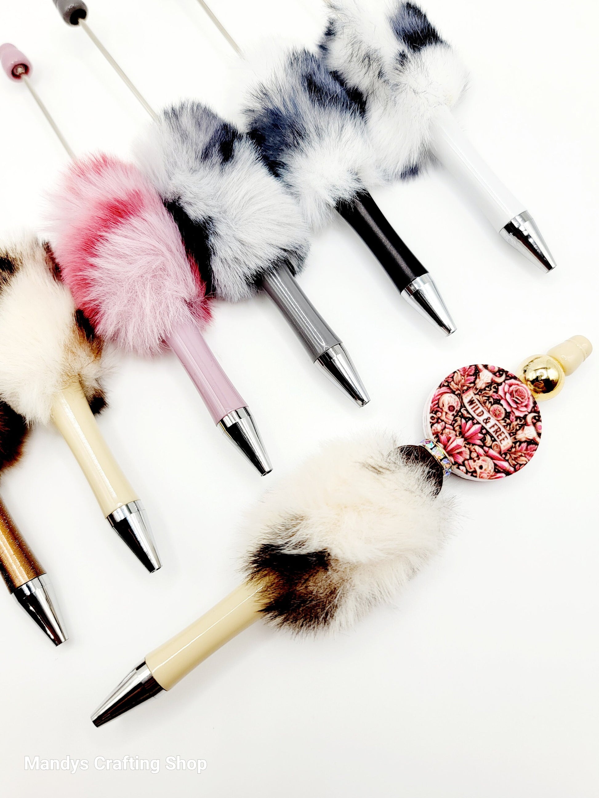 Decorative pens with feather tips on a white background