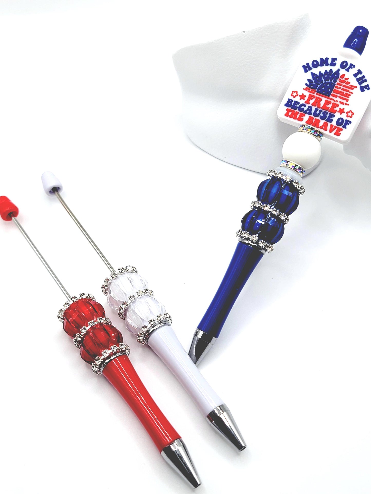 Three decorative pens with red, white, and blue accents on a white background.