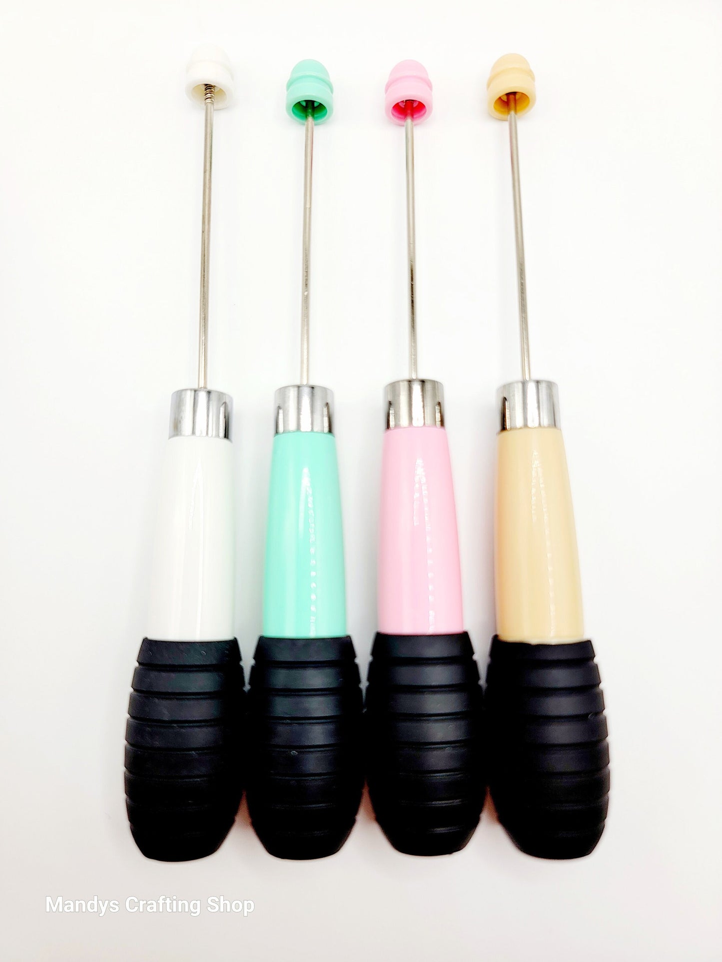 Four colorful pens with black bases on a white background