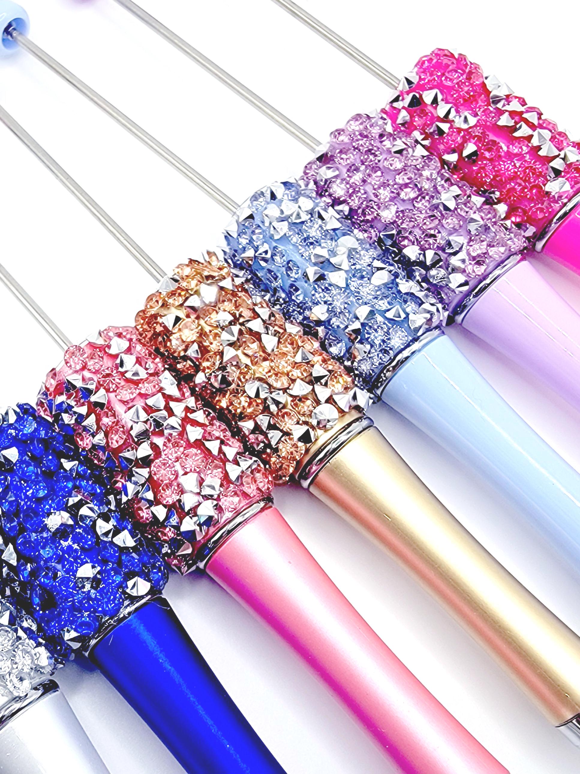 Colorful glittery pens with metallic accents on a white background