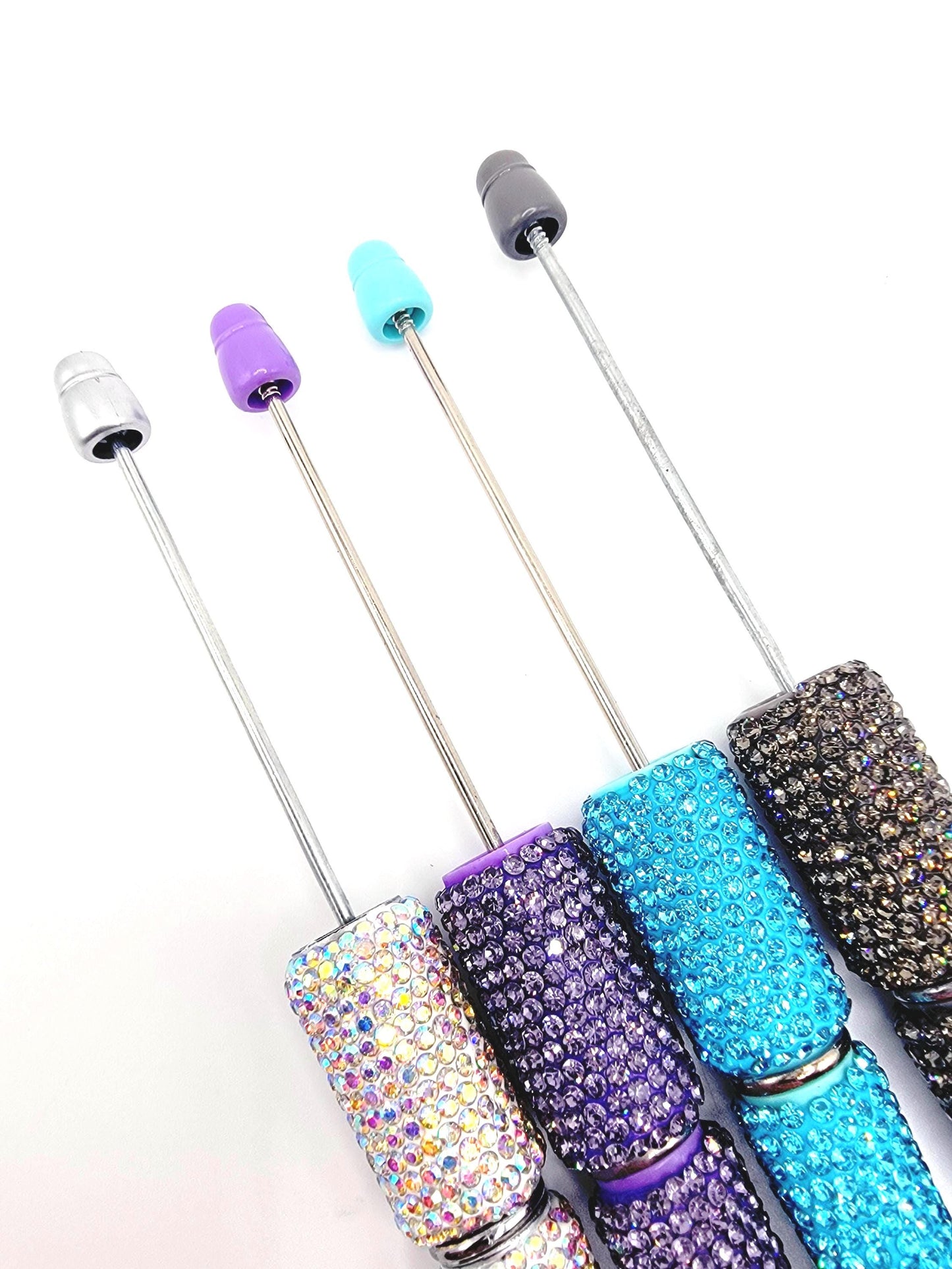 Set of four glittery cocktail straws with colorful ends on a white background