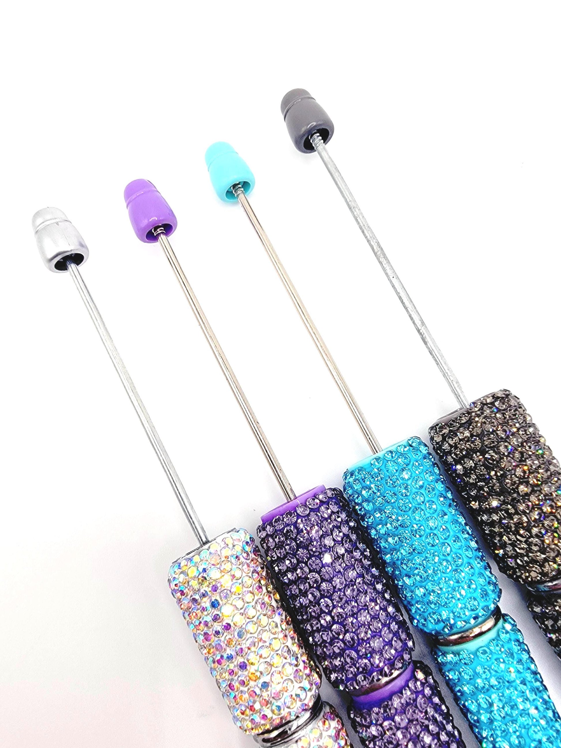 Set of four glittery cocktail straws with colorful ends on a white background