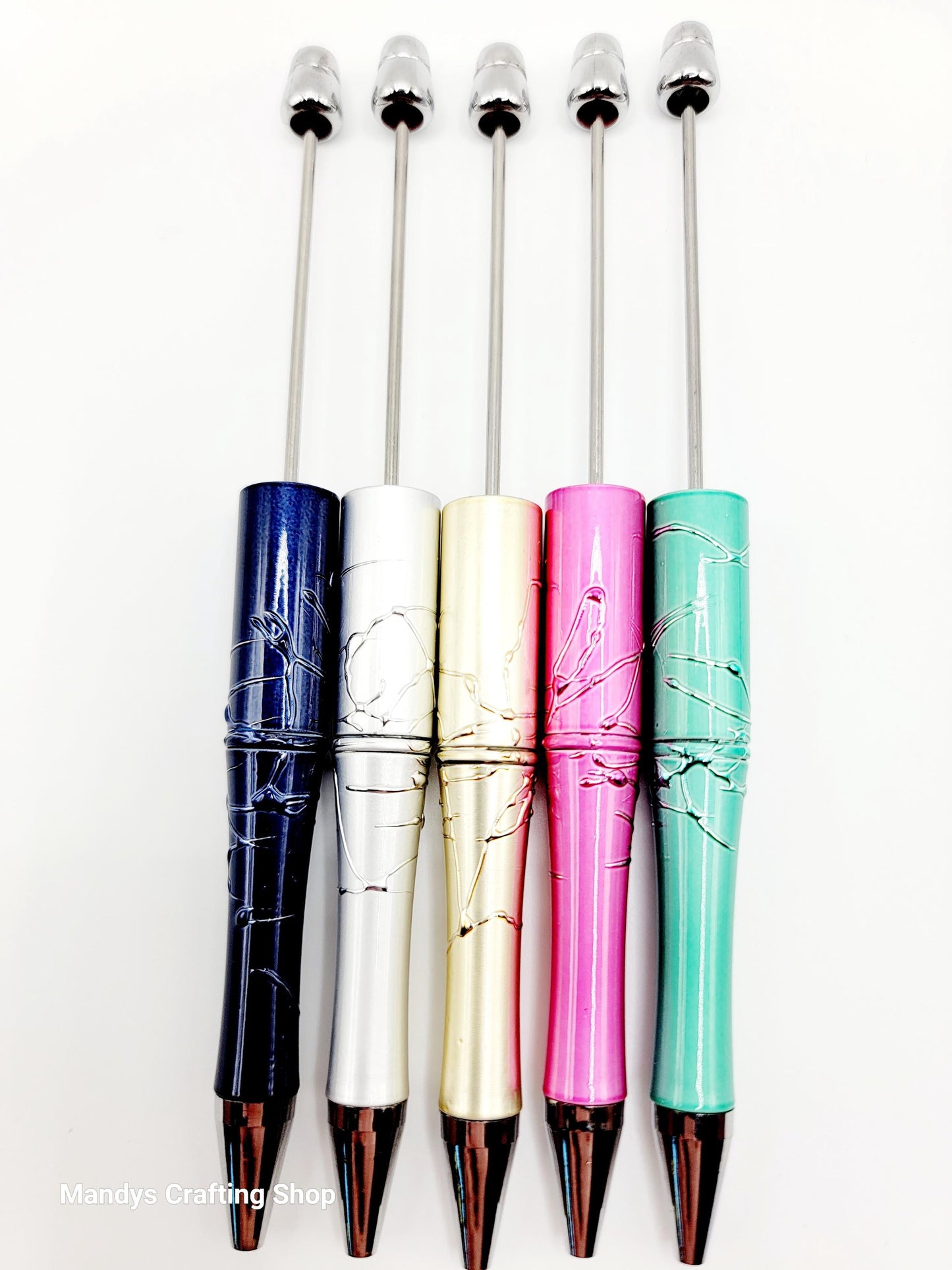 Five colorful pens with decorative designs on a white background