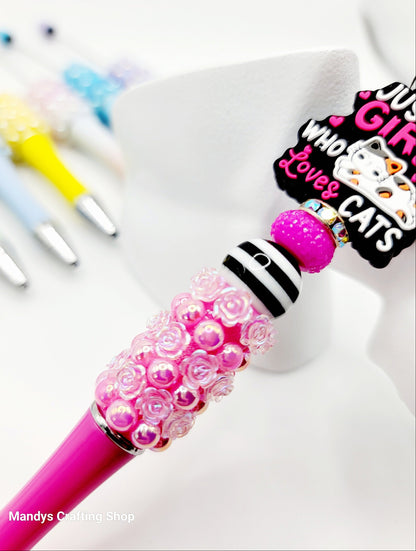 Pink beaded pen with a colorful character design on a white background
