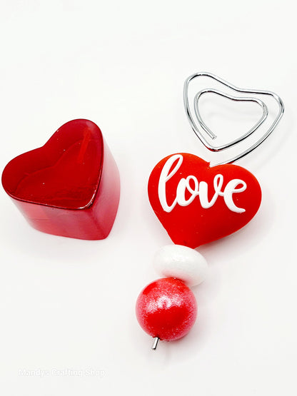 Red heart-shaped objects with 'love' text on a white background