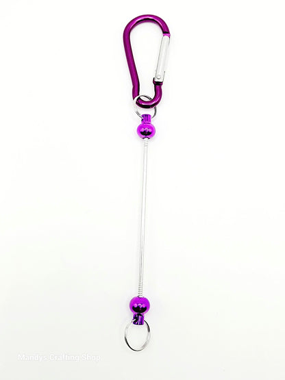Purple carabiner with a long string on a white background