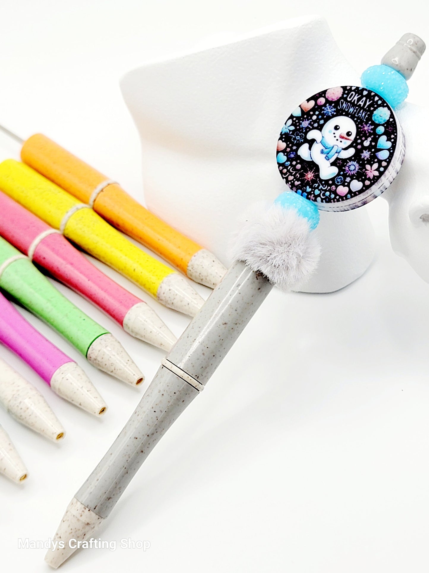Decorative pen with colorful markers and a unicorn-themed lid on a white background
