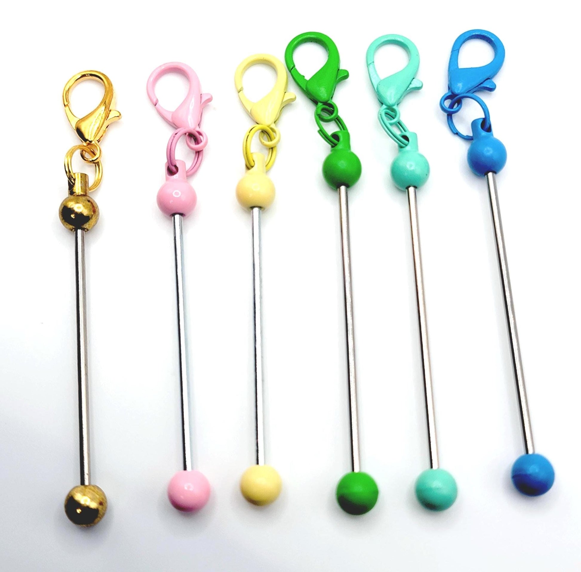 Set of colorful keychain straws with metal stems on a white background