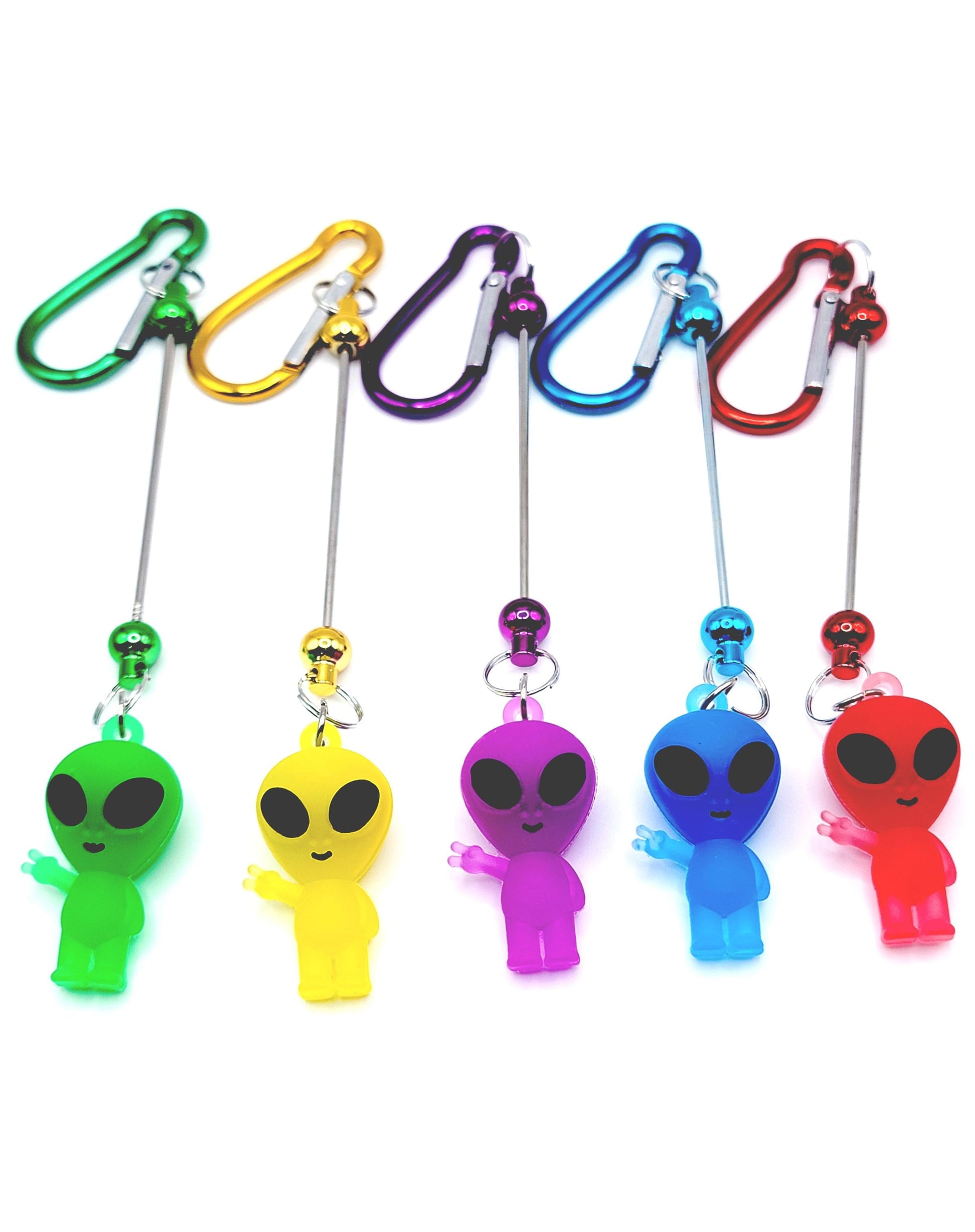 Set of colorful alien-shaped keychains with carabiners on a white background