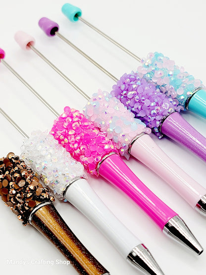 Decorative makeup brushes with colorful handles and glittery accents on a white background