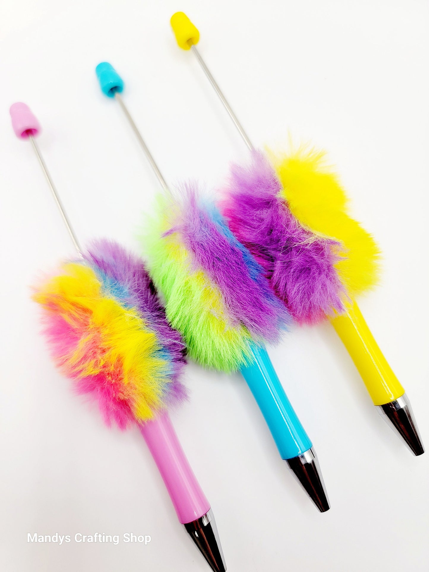 Colorful feather duster pens on a white background